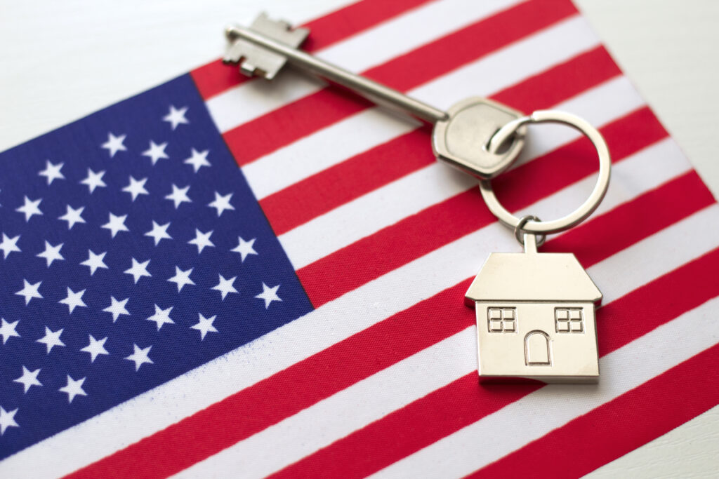 House with the flag of USA. Immigration to America. Buying real estate. Houses for rent. Property price. Acquisition of real estate in another state.