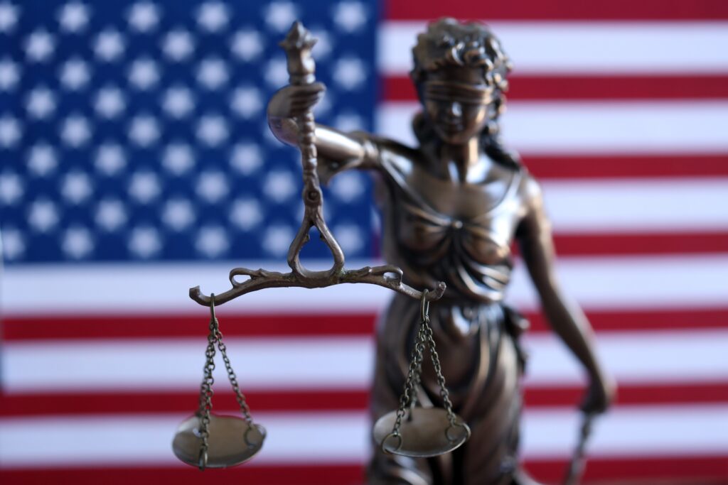 American constitution, law and legal system, statue of lady justice with scales of justice with american flag